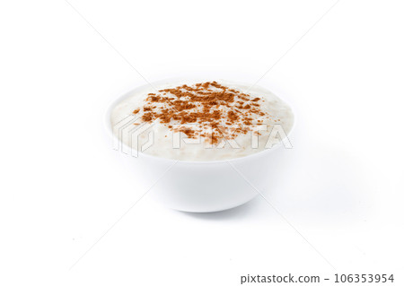 Arroz con leche. Rice pudding with cinnamon in clay bowl isolated on white background. Arroz con leche. Rice pudding with cinnamon in clay bowl isolated on white background. 106353954