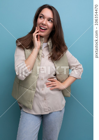 surprised brunette young lady in casual outfit on studio background 106354470