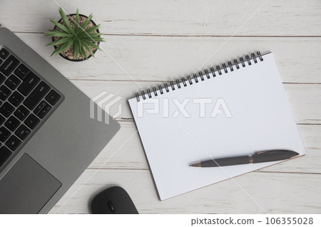 Top view of laptop, table plant, blank notepad and mouse on white cover background with customizable space for text. Copy space Top view of laptop, table plant, blank notepad and mouse on white cover background with customizable space for text. Copy space 106355028