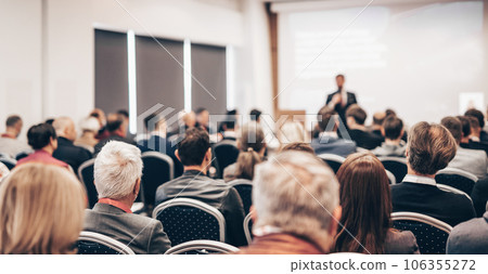 Speaker giving a talk in conference hall at business event. Rear view of unrecognizable people in audience at the conference hall. Business and entrepreneurship concept 106355272