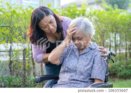 Asian elderly woman headache while sitting on wheelchair at park, healthy strong medical concept. 106355697