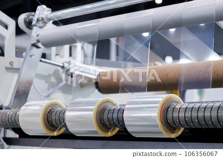 roll of plastic packaging film on the automatic packing machine in food product factory. industrial and technology concept. 106356067