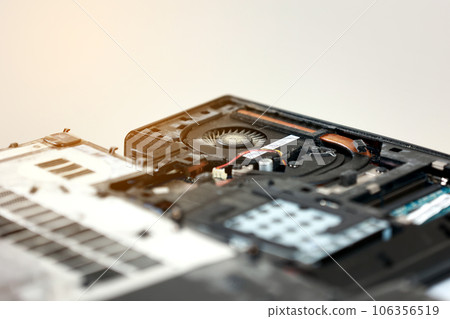 Fixing laptop. Repairman holds cooling fan and repairs from overheating. Disassembling computer, replacement, clean dust and dirt cooling system on notebook. Professional electronic device service Fixing laptop. Repairman holds cooling fan and repairs from overheating. Disassembling computer, replacement, clean dust and dirt cooling system on notebook. Professional electronic device service 106356519