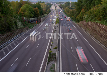 Long exposure photo of traffic with blurred traces from cars, top view. road, cars, blurred traffic, evening, top view. Highway at evening, blue hour illuminated by the traffic of cars 106357883