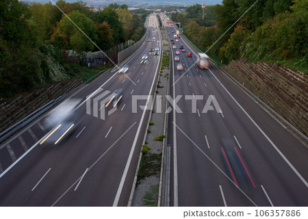 Night lights from car headlights on roundabout in night city. Traces of headlights on the road at night, long exposure. Drone aerial shot. Panoramic aerial view of illuminated road overpass and road 106357886