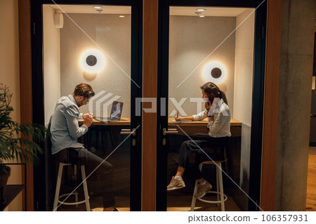 Two diverse business people working in modern coworking space Two diverse business people working in modern coworking space 106357931