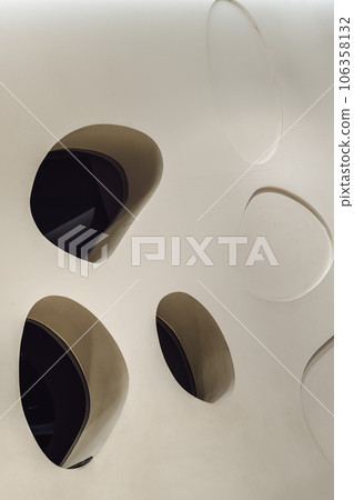 Glass mirrored panels are embedded in the white wall and are decorated in the living room. Glass mirrored panels are embedded in the white wall and are decorated in the living room. 106358132