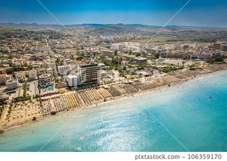Golem, Durres, Albania - 22 august 2023: Aerial view to sandy beach full of umbrellas and people in summer season 2023 Golem, Durres, Albania - 22 august 2023: Aerial view to sandy beach full of umbrellas and people in summer season 2023 106359170