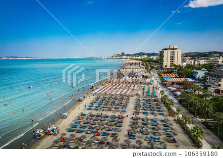 Golem, Durres, Albania - 22 august 2023: Aerial view to sandy beach full of umbrellas and people in summer season 2023 106359180