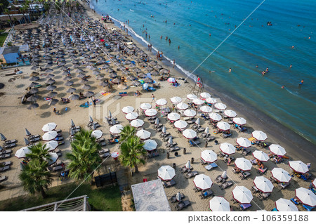 Golem, Durres, Albania - 22 august 2023: Aerial view to sandy beach full of umbrellas and people in summer season 2023 Golem, Durres, Albania - 22 august 2023: Aerial view to sandy beach full of umbrellas and people in summer season 2023 106359188