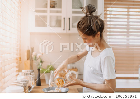 Woman preparing breakfast in the kitchen in the morning. 106359951