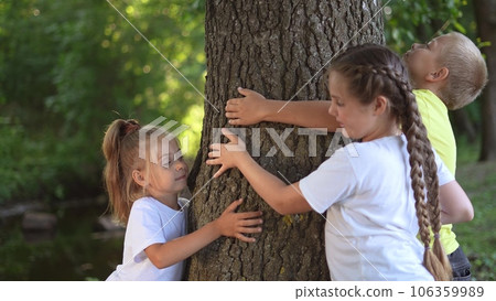 children hugging a tree in the forest. happy family childhood dream concept. children spend lifestyle time together outdoors and hug the trunk of a tree. environmental protection love for nature 106359989