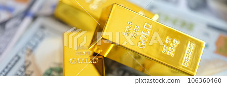 Close-up yellow gold ingots lie on money 106360460