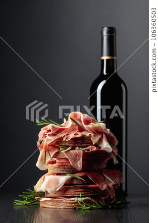 Spanish jamon or Italian prosciutto with bread, rosemary, and red wine. Spanish jamon or Italian prosciutto with bread, rosemary, and red wine. 106360503