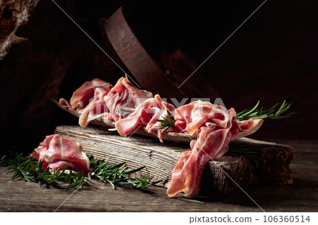 Italian prosciutto crudo or Spanish jamon with rosemary. Italian prosciutto crudo or Spanish jamon with rosemary. 106360514