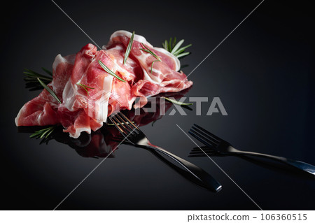 Italian prosciutto or Spanish jamon with rosemary. Italian prosciutto or Spanish jamon with rosemary. 106360515