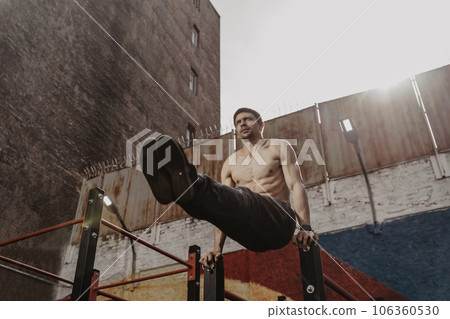 Young man practicing calisthenics. 106360530