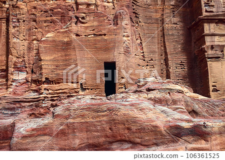 View of the wall with the door, the entrance to the temple, carved into the red sandstone rock in the canyon. Petra, Jordan View of the wall with the door, the entrance to the temple, carved into the red sandstone rock in the canyon. Petra, Jordan 106361525