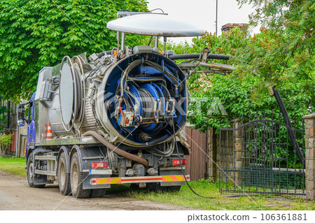 Truck mounted combined vacuum suction and canal jetting machine in action in city utilities 106361881