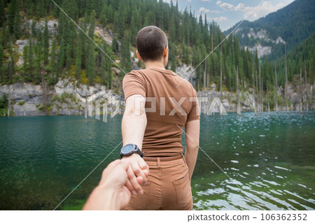 Follow me. A woman brought her man on a date in nature. Spend time on the mountain lake Kaindy in Qazaqstan Follow me. A woman brought her man on a date in nature. Spend time on the mountain lake Kaindy in Qazaqstan 106362352