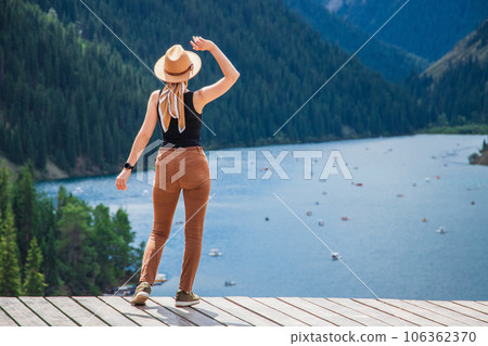 Woman look at amazing scenic view on Kolsay lake in Kolsai Koldery gorge near Almaty, nature of Kazakhstan National Park, Central Asia 106362370