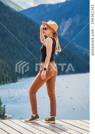 Young woman stands in the background Kolsay lake in Kolsai Koldery gorge near Almaty, nature of Kazakhstan National Park, Central Asia Young woman stands in the background Kolsay lake in Kolsai Koldery gorge near Almaty, nature of Kazakhstan National Park, Central Asia 106362381