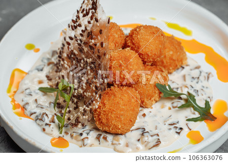 Potato croquettes - mashed potatoes balls breaded and deep fried, served with different sauce. 106363076