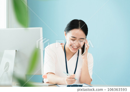 Medical staff woman confirming by phone 106363593