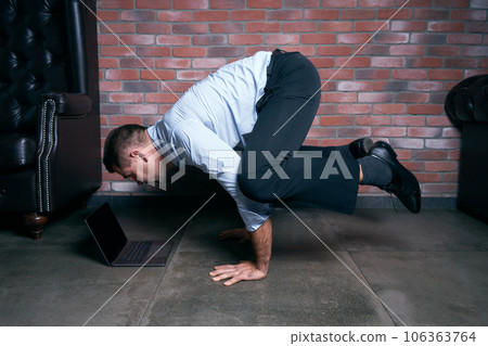 Businessman doing yoga posing duringwork break 106363764