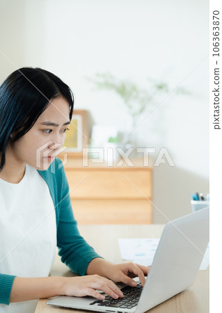 便攜式計算機上工作的年輕女子 便攜式計算機上工作的年輕女子 106363870