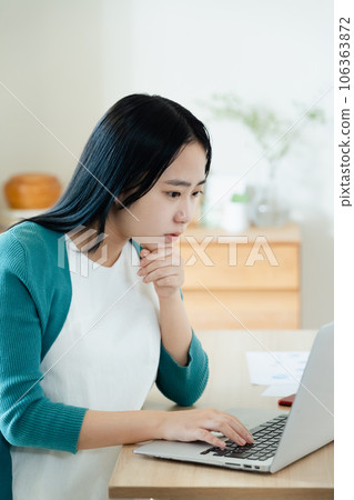 便攜式計算機上工作的年輕女子 便攜式計算機上工作的年輕女子 106363872