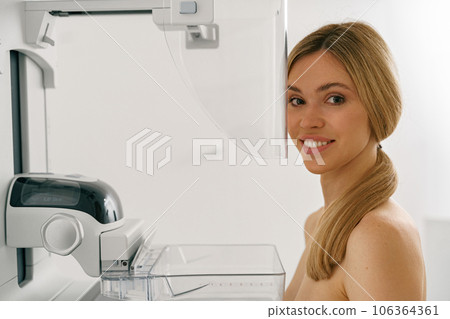 Young woman doing mammogram x ray for breast cancer prevention screening at modern hospital Young woman doing mammogram x ray for breast cancer prevention screening at modern hospital 106364361