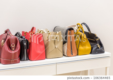 Collection of handbags standing in a row Collection of handbags standing in a row 106364465