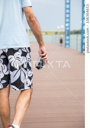 Back view of man holding vintage camera 106364653