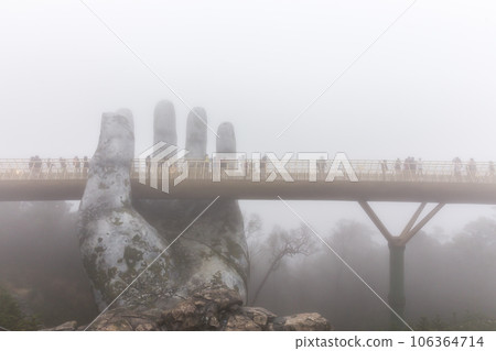 Danang , Vietnam - JANUARY 04, 2019 : View in Fog of the Golden Bridge on Ba Na Hills in Da Nang on rainy day 106364714