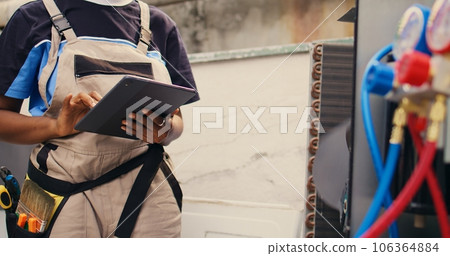 Close up of expert electrician calibrating ac gauges vacuum pump during comissioned hvac system troubleshooting. Experienced wireman looking for potential low pressure in condenser cooling system 106364884