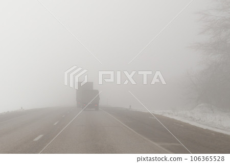 trucks on a foggy road 106365528