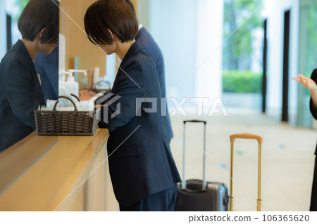 A businessman at the reception desk in the lobby A businessman at the reception desk in the lobby 106365620