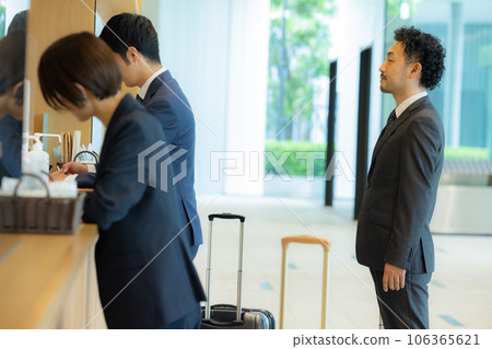 A businessman at the reception desk in the lobby A businessman at the reception desk in the lobby 106365621