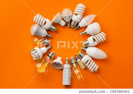 Many light bulbs on bright orange background 106366401