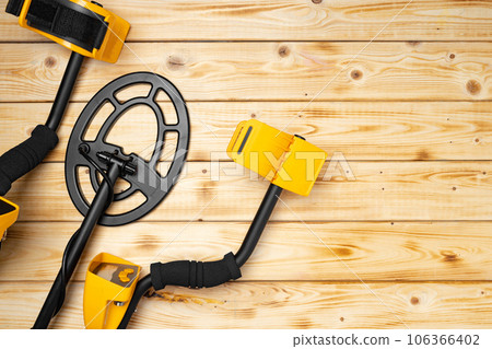 Metal detector on wooden background top view 106366402