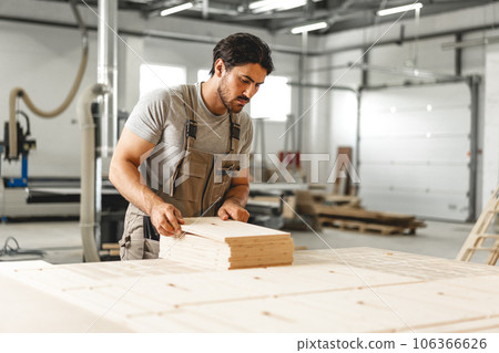 Young man doing woodwork in carpentry factory 106366626