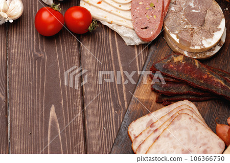 Assortment of meat and sausage on wooden surface 106366750