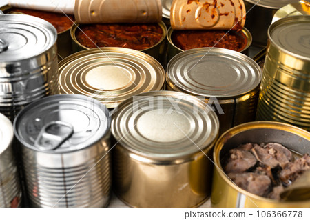 Many cans with conserved fish on wooden table 106366778