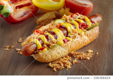 Hot dog with yellow mustard and ketchup on wooden board Hot dog with yellow mustard and ketchup on wooden board 106366829