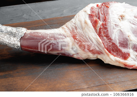 Raw beef leg on brown wooden board Raw beef leg on brown wooden board 106366916