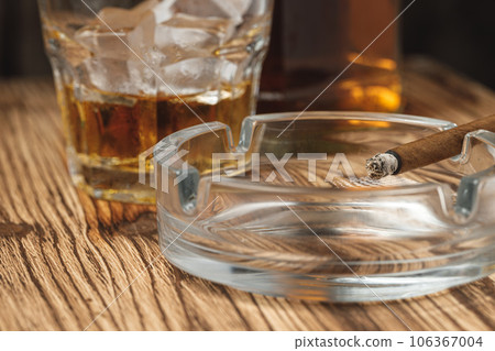 Lighted cigar in an ashtray close up 106367004