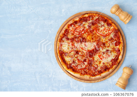 Delicious pizza with sausages on gray background Delicious pizza with sausages on gray background 106367076