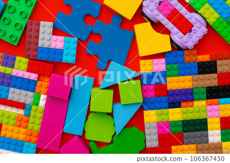 Plastic constructor details on red background close up Plastic constructor details on red background close up 106367430
