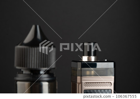 Vape and vape liquid bottles against black background 106367555